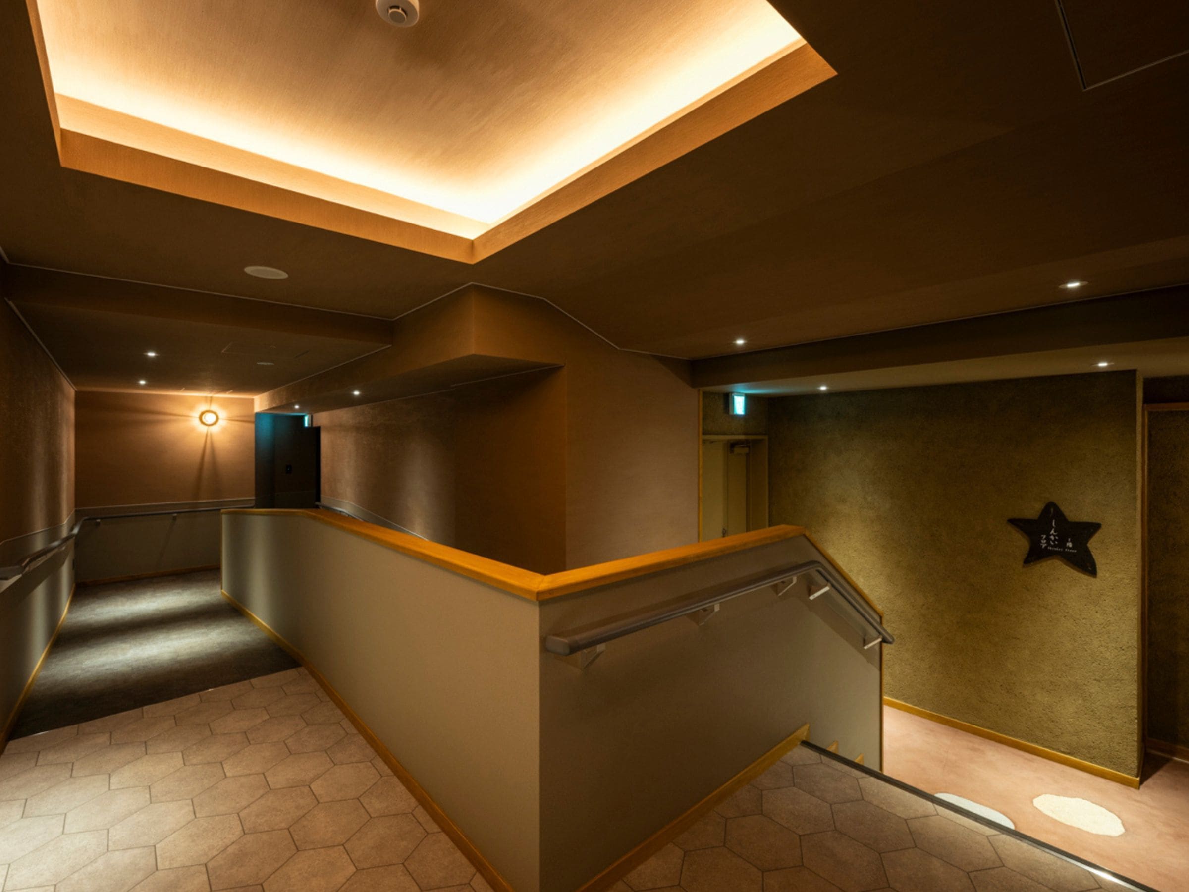 A modern interior with a staircase, a star-shaped wall decoration, and a ceiling light fixture.