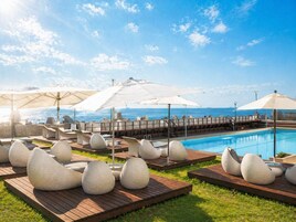 Una piscina al aire libre de temporada, sombrillas