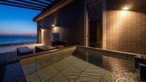 Zona de piscina exterior con una pérgola, una puerta y vistas al mar.
