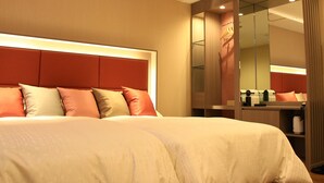 Ein Hotelzimmer mit einem großen Bett, einem Spiegel und einem Kleiderschrank.