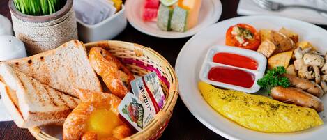 A breakfast setting with toast, eggs, sausages, and a variety of fruits and vegetables.