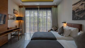 A modern hotel room with a large bed, a desk, and a TV.