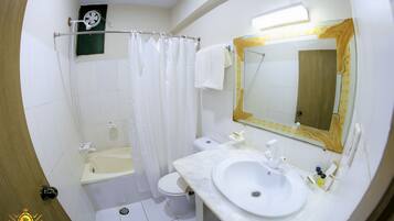 A bathroom with a bathtub, toilet, and sink.