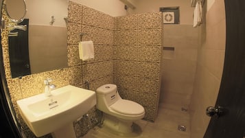 A bathroom with a sink, toilet, and patterned tiles.