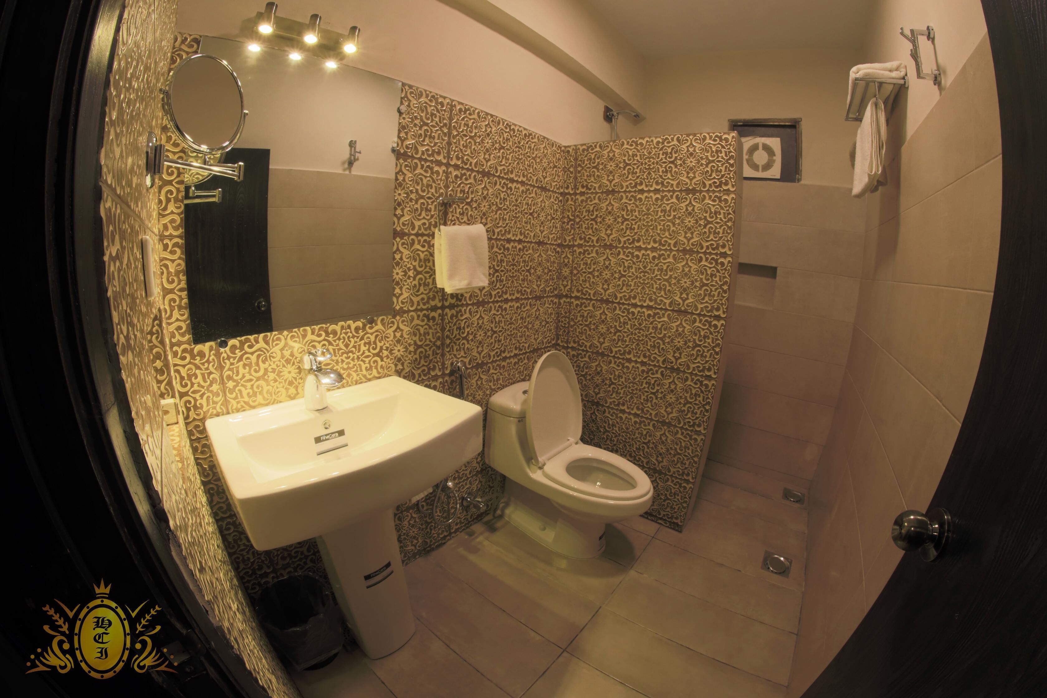 Un baño con lavamanos, inodoro y ducha.