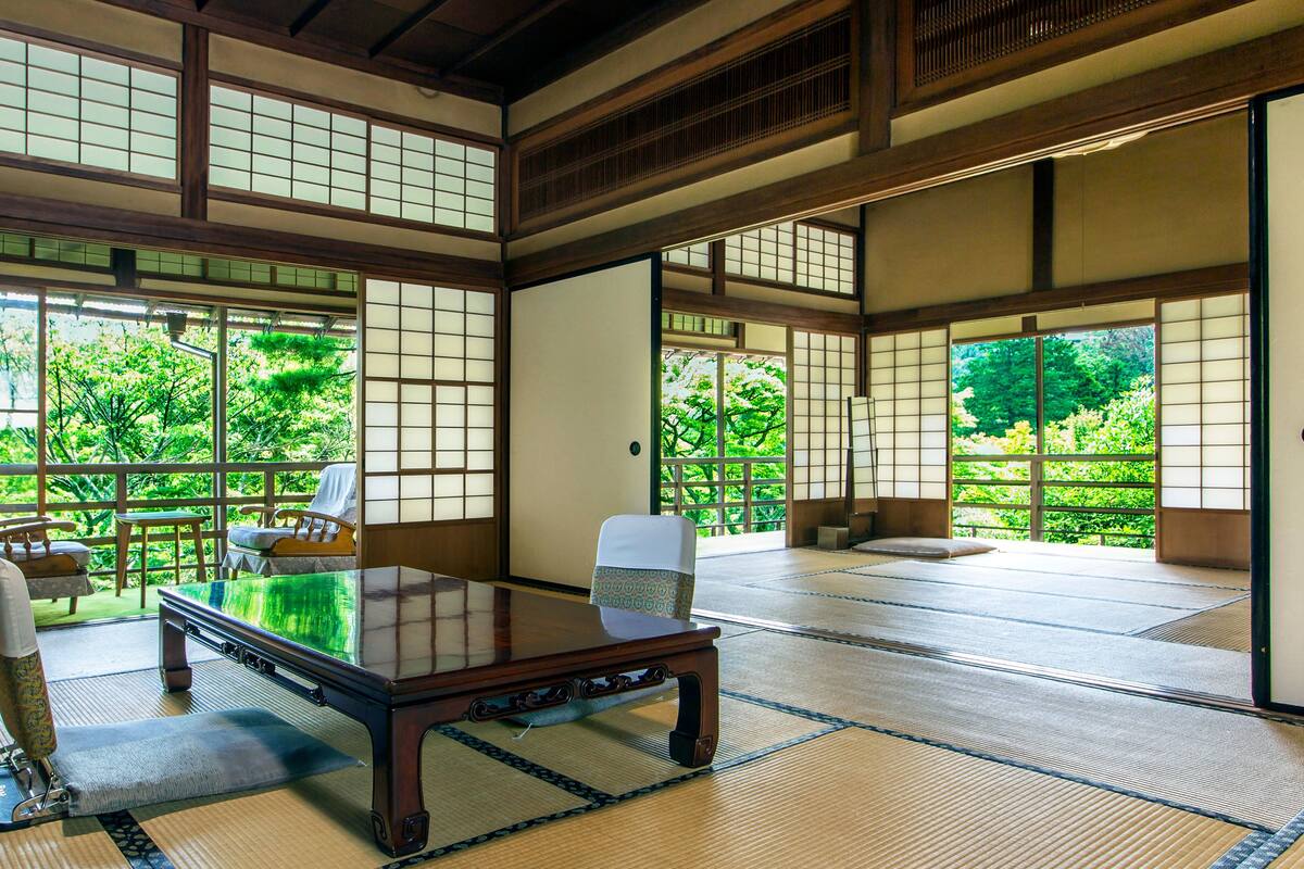 A traditional Japanese room with tatami flooring, a low table, and shoji screens.