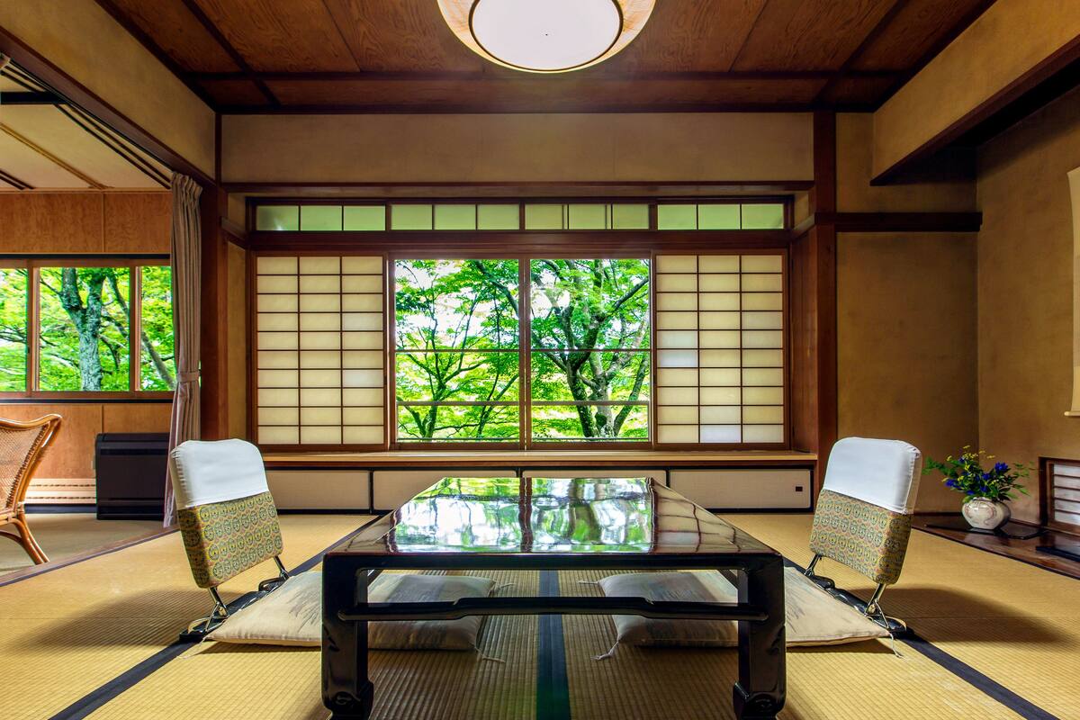 A traditional Japanese room with tatami flooring, a low table, and shoji screens.