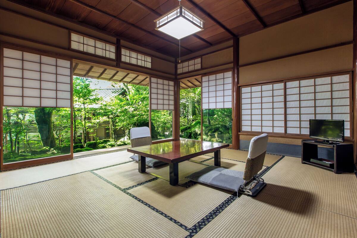 A traditional Japanese room with tatami flooring, a low table, and sliding doors.