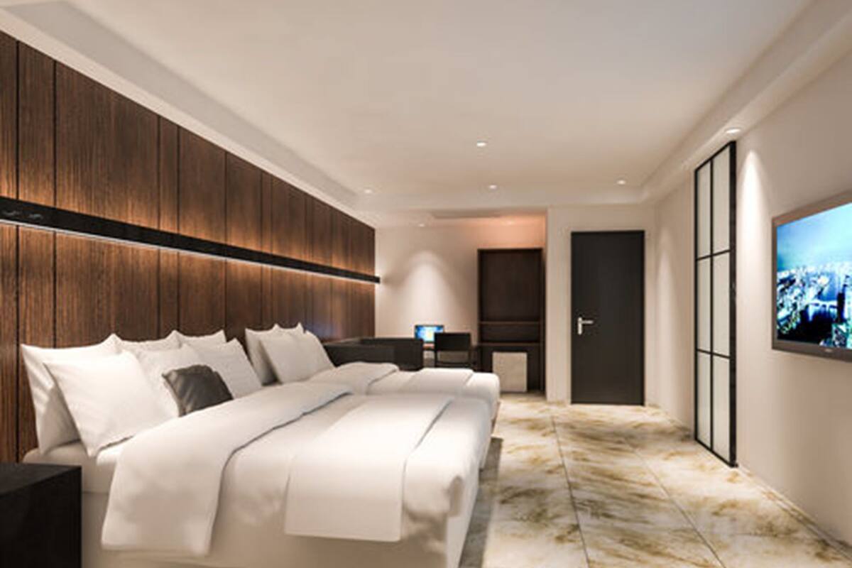 Un dormitorio moderno con una cama grande, televisor y vista a la ciudad.