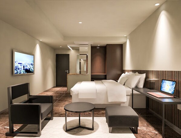 A modern hotel room with a bed, bedside table, chair, and a TV.