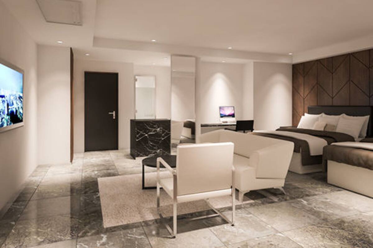 Una habitación de hotel moderna con una cama grande, un escritorio, una silla y un televisor.