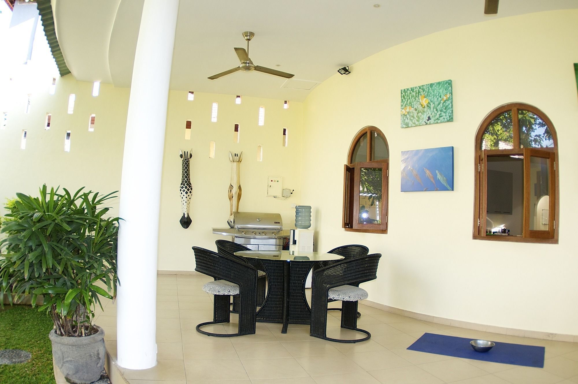 A dining area with a table and chairs, a ceiling fan, and a potted plant.