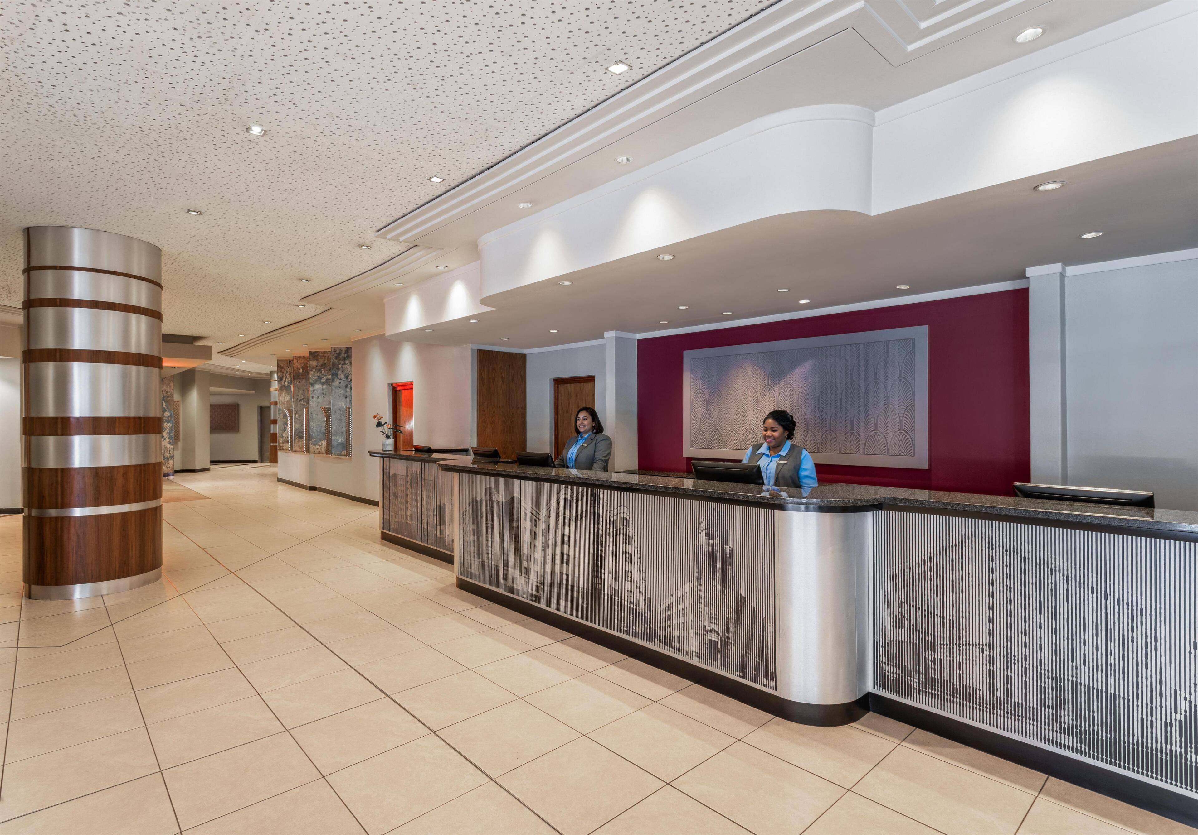 Una reception dal design moderno, con un'imponente colonna e un pavimento piastrellato.