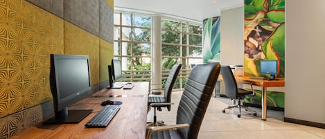 Un espacio de oficina con un escritorio de madera, dos monitores de computadora, un teclado y dos sillas de oficina.