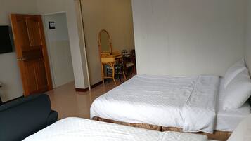 Ein Hotelzimmer mit zwei Betten, einem Schreibtisch mit Stuhl, einem Spiegel und einem Kleiderschrank.