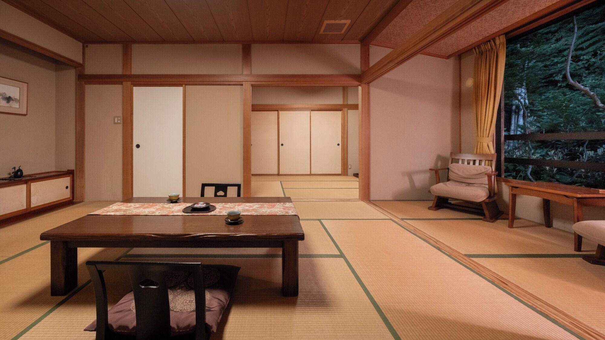 Una estança japonesa tradicional amb paviment de tatami, una taula baixa i portes corredisses.