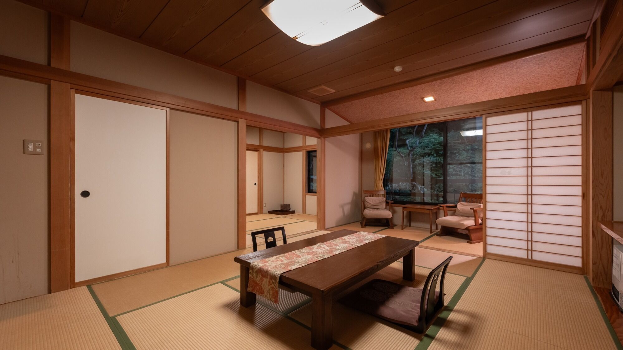 Una tradizionale stanza giapponese con pavimento in tatami, un tavolino e porte scorrevoli.