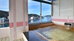 Un jacuzzi con vistas a un puente y edificios al otro lado del agua.