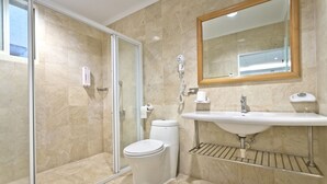 Ein modernes Badezimmer mit Duschkabine, Toilette, Waschbecken und Spiegel.