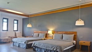 Ein modernes Hotelzimmer mit zwei Betten, Holzboden und einem großen Fenster.