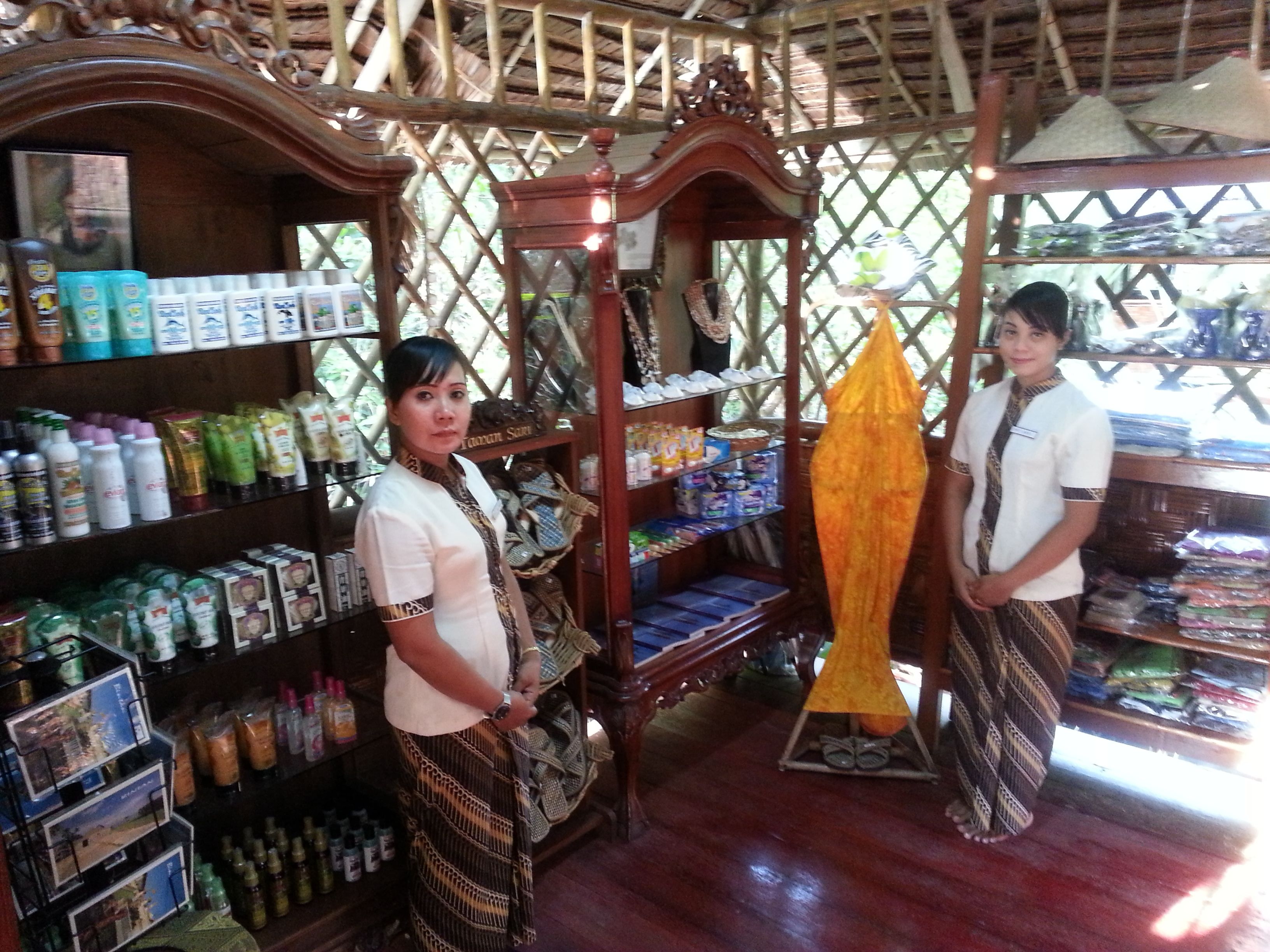 A store with shelves stocked with various products, a wooden display, and a hanging yellow item.