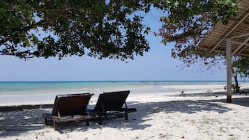 Een privéstrand, ligstoelen aan het strand, strandlakens, snorkelen