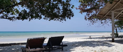 Een privéstrand, ligstoelen aan het strand, strandlakens, snorkelen