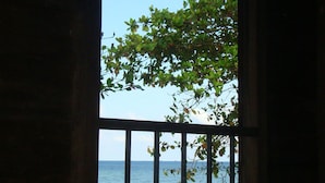 A window with a view of a beach and ocean. - Mutiara Beach Resort (Bintan)