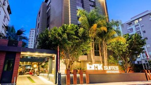 A modern building with a sign for 'ETK Suites Apartments'.