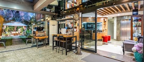 A modern interior with a dining area, kitchen, and a view of the outdoors.