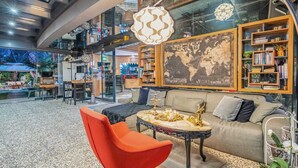 A modern interior with a sofa, red chair, and a coffee table with decorative items.