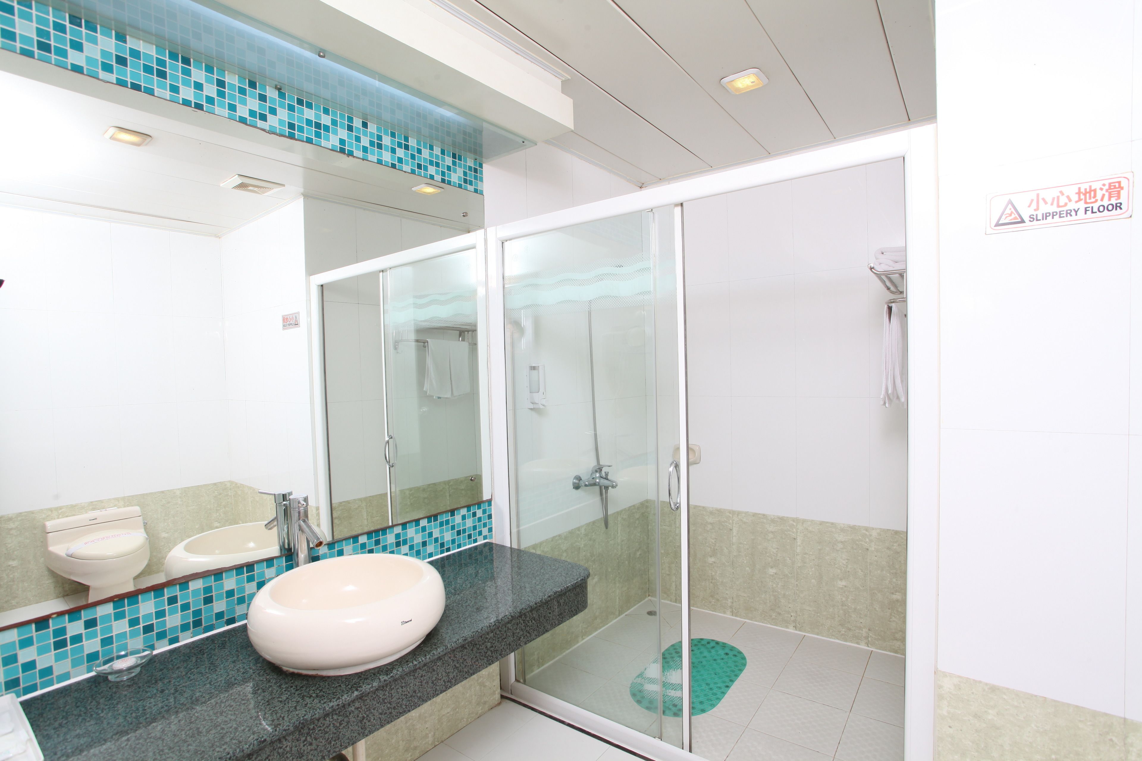 A bathroom with two sinks, a glass shower enclosure, and a tiled floor.