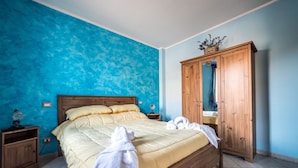 A bedroom with a bed, wooden wardrobe, and a nightstand. - Locanda Belvedere (Rocchetta a Volturno)