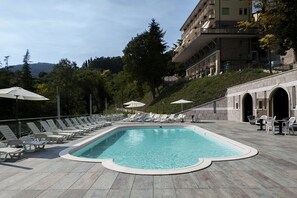 Piscine extérieure, parasols de plage, chaises longues