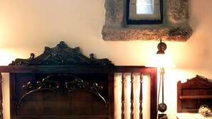 A room with a wooden headboard, a bedside lamp, and a small wooden shelf.