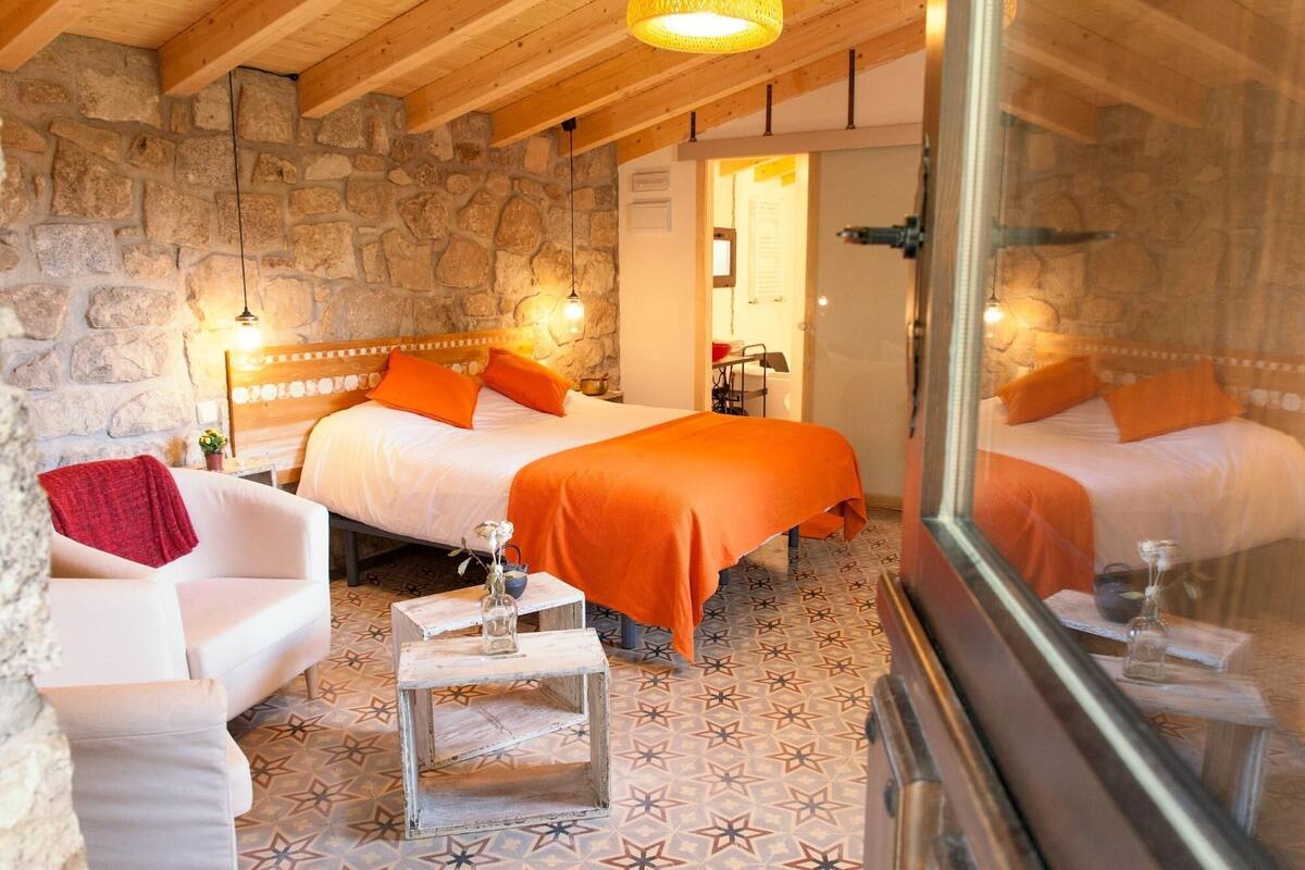 Una habitación acogedora con dos camas, una mesita y un sofá.