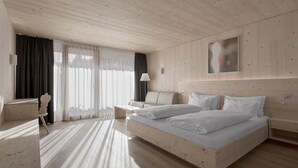 Una habitación de hotel moderna con una cama grande, un escritorio y una silla.