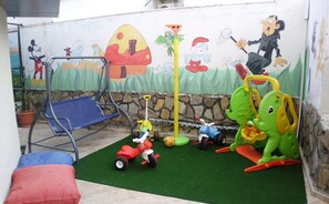 A children's play area with a slide, a swing, and various toys. - Pekcan Hotel (Alanya)