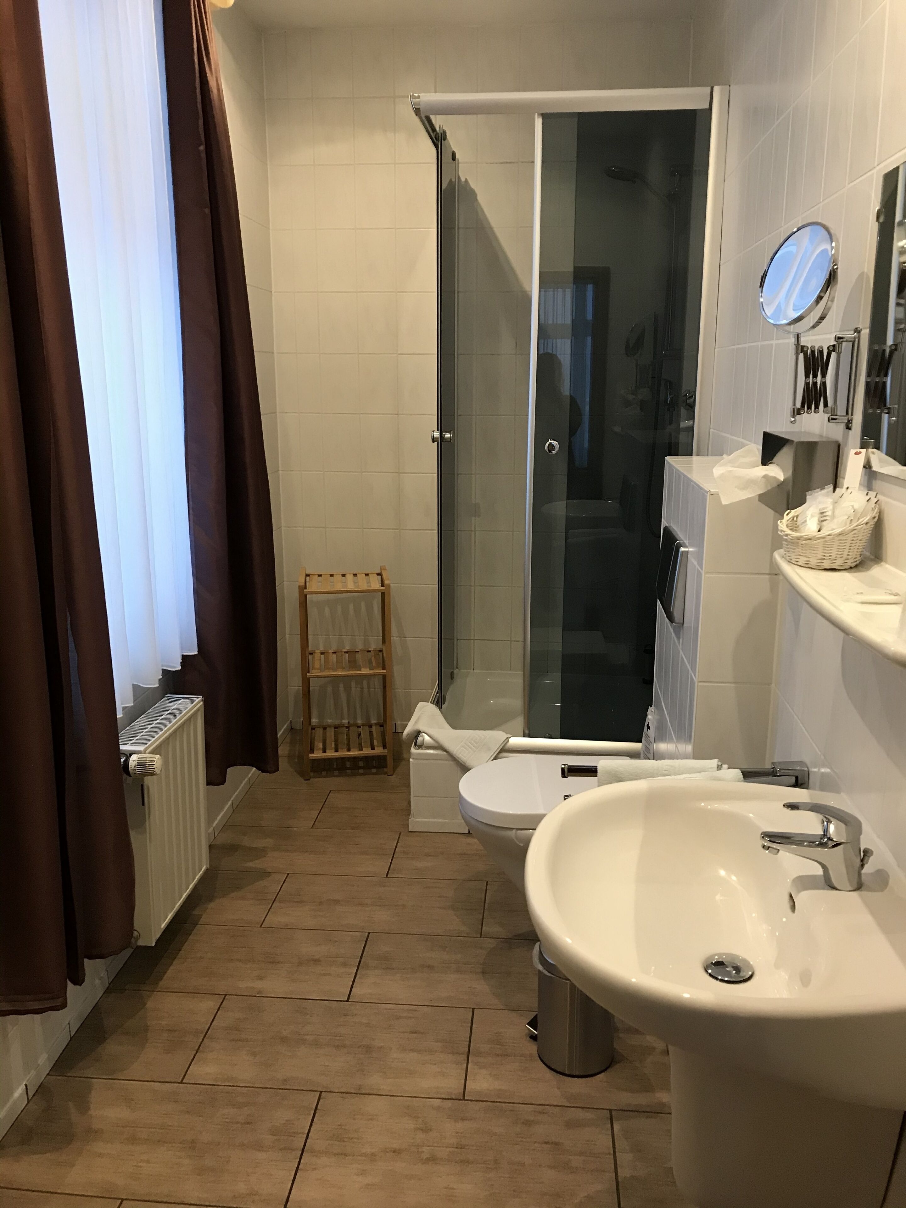 A bathroom with a shower, toilet, and sink.