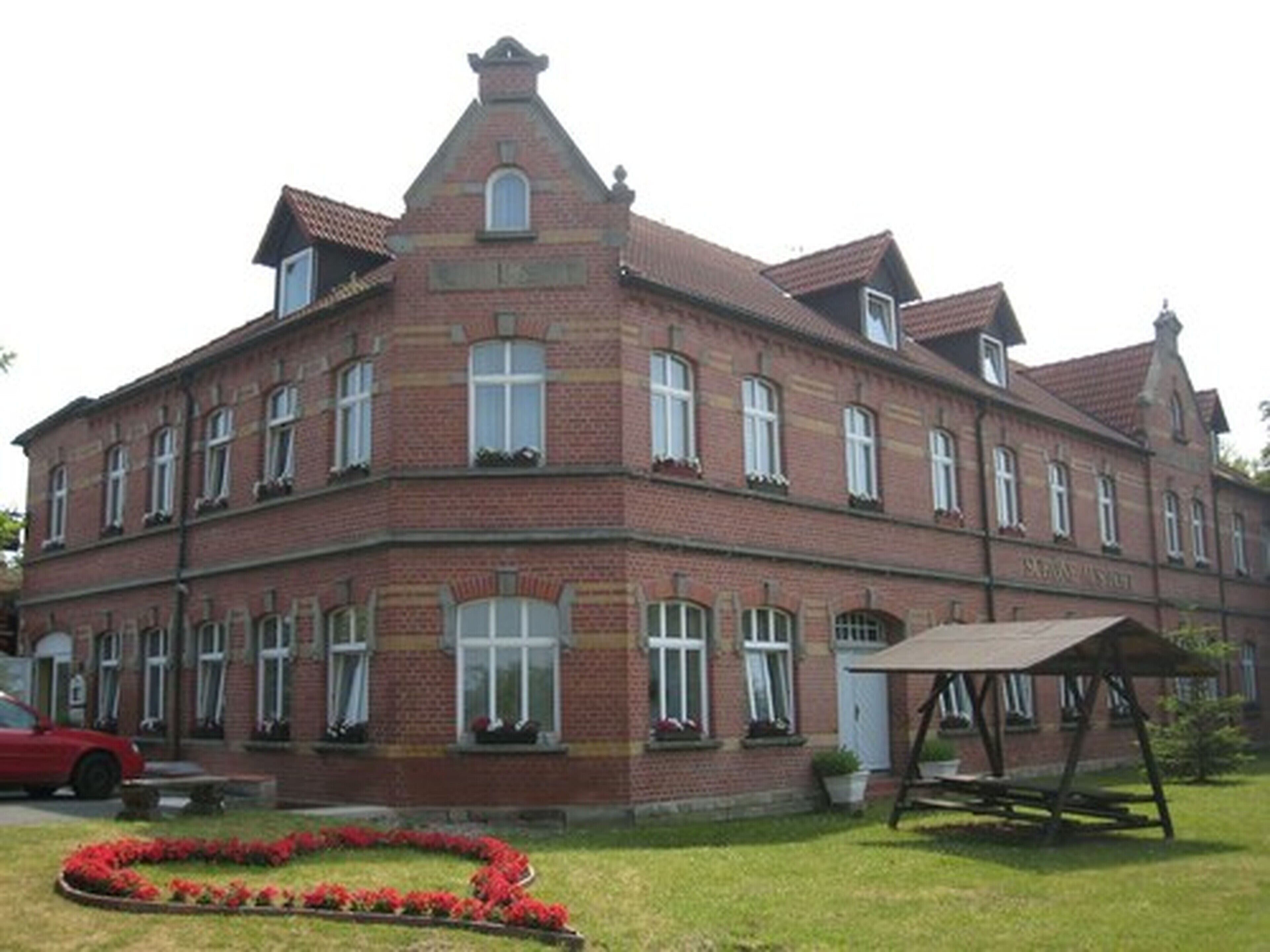 Ein großes, rechteckiges Backsteinhaus mit vielen Fenstern und einem zentralen Eingang.