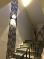 En trappa med en vägg som har en intressant yta och en lampa.