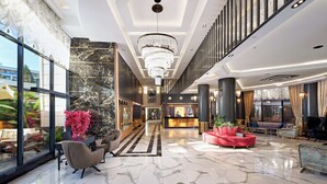 A spacious lobby with a marble floor, a chandelier, and a reception desk. - Grand Uysal Beach&Spa Hotel - All inclusive (Alanya)