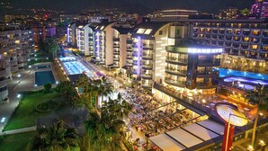 A hotel with multiple floors, outdoor pool, and dining areas. - Grand Uysal Beach&Spa Hotel - All inclusive (Alanya)