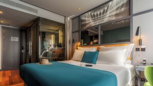 Una habitación de hotel moderna con una cama grande, un escritorio y un espejo.