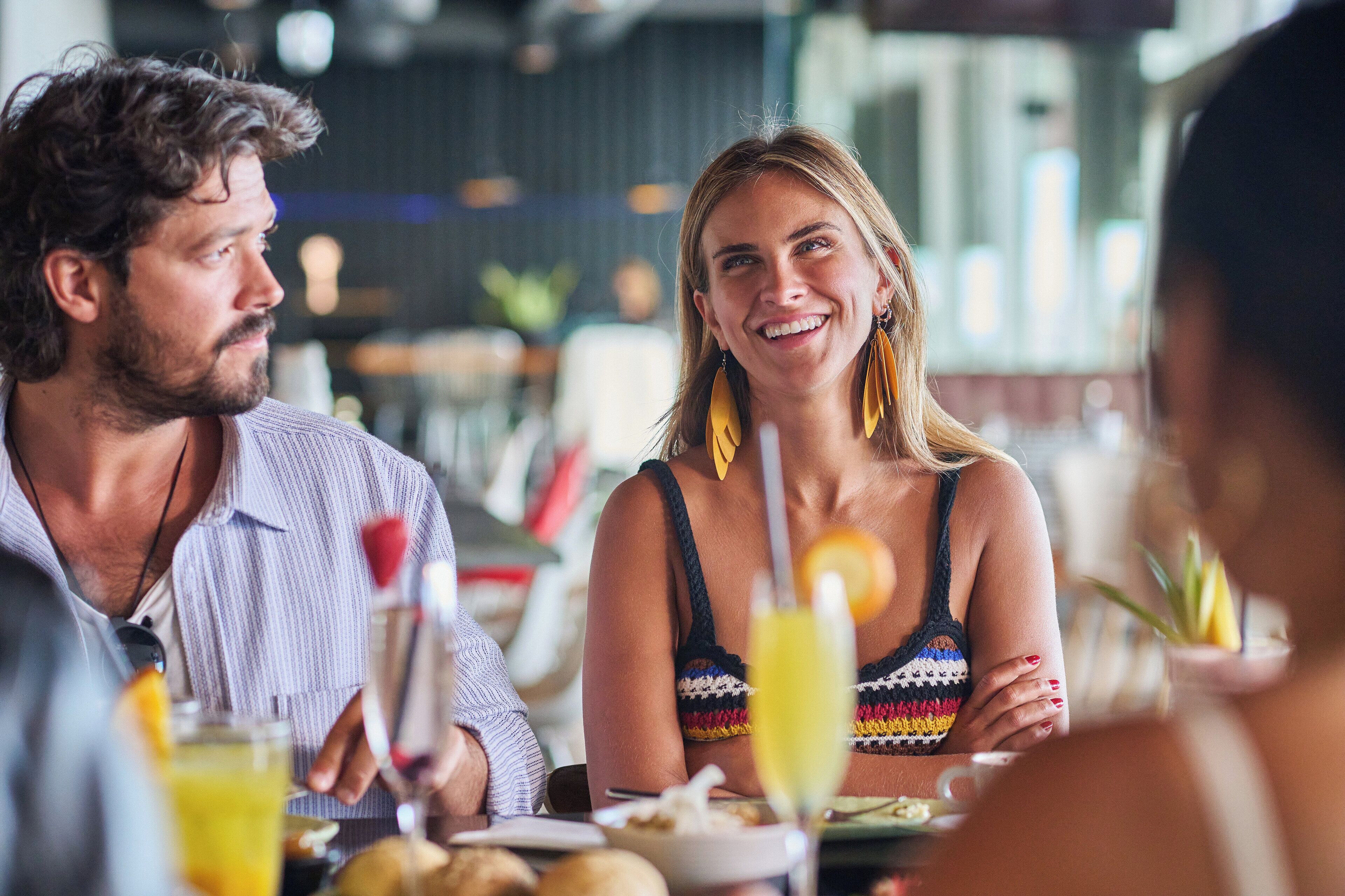 Une salle de restaurant avec des tables, des chaises et des clients qui prennent leur repas.