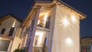 A two-story house with a balcony, a garage, and potted plants. - Bed & Breakfast Le Due G (Varese)