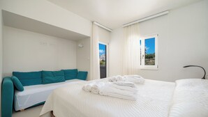 Et moderne hotelværelse med en stor seng, en sofa og udsigt over byen.