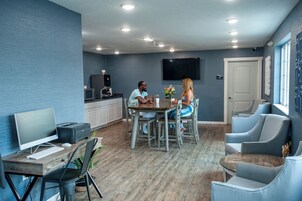 Una cocina moderna con comedor, televisión de pantalla plana y un espacio para sentarse.