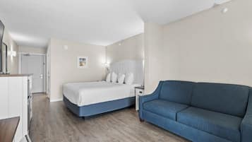 Une chambre à coucher avec un lit, un canapé bleu, une table de chevet et une commode.