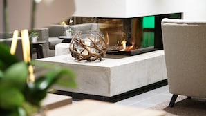 A modern living room with a fireplace, a glass sculpture, and a comfortable seating area.